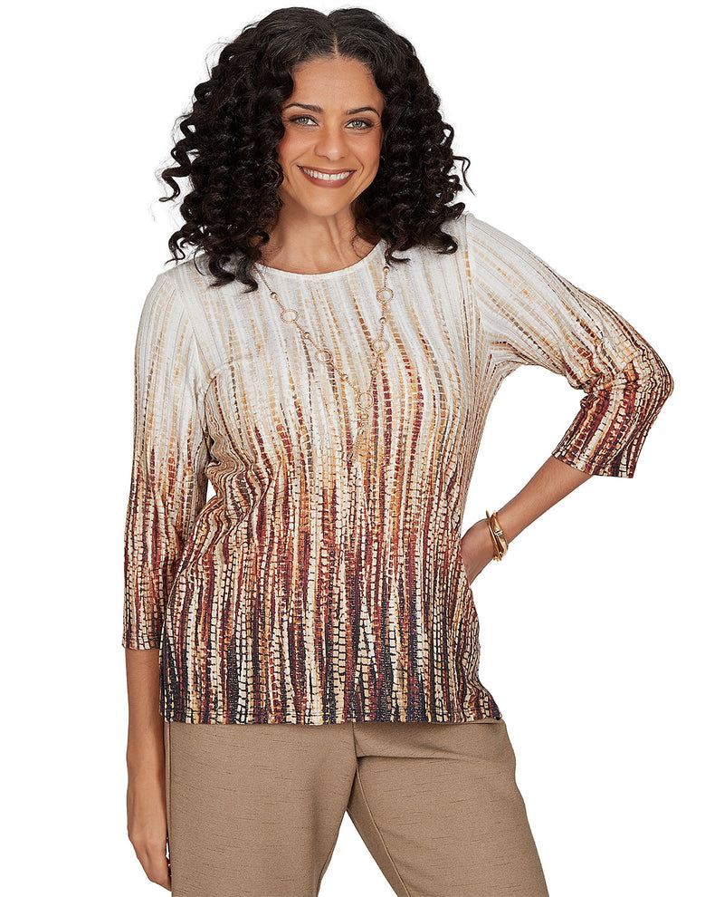 Woman wearing a patterned top and beige pants on a white background