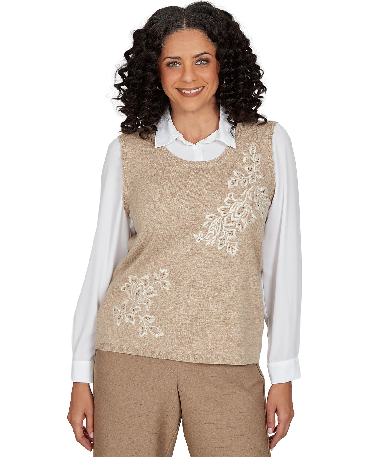 Woman wearing a beige vest with floral embroidery on a white background