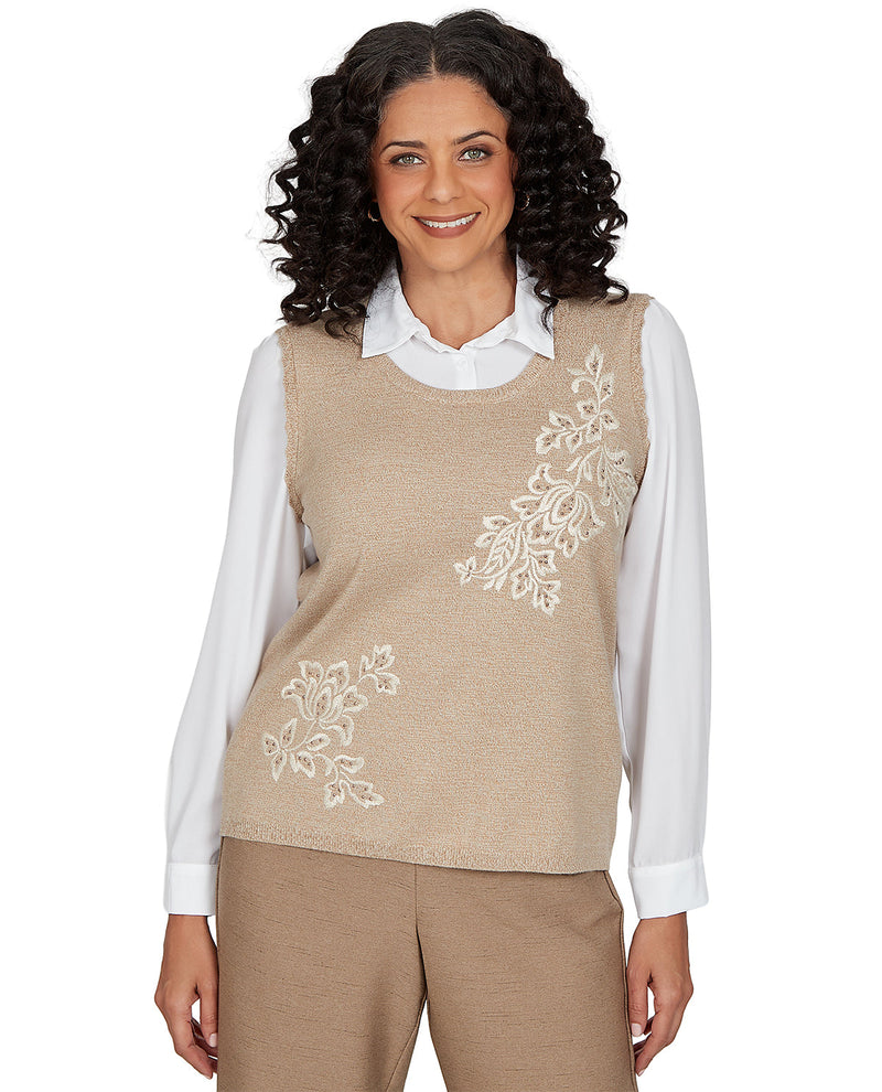 Woman wearing a beige embroidered vest over a white shirt on a white background