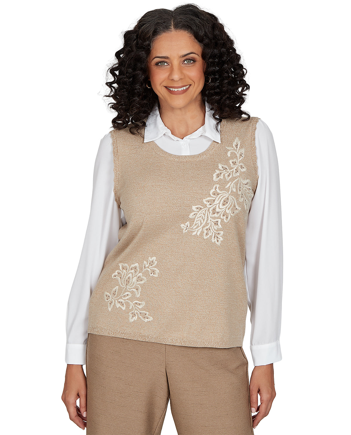 Woman wearing a beige embroidered vest over a white shirt on a white background