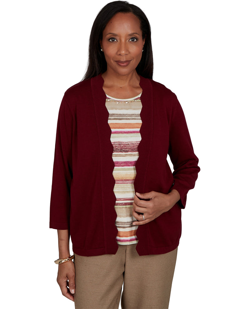 Woman wearing a burgundy cardigan over a striped shirt on a white background