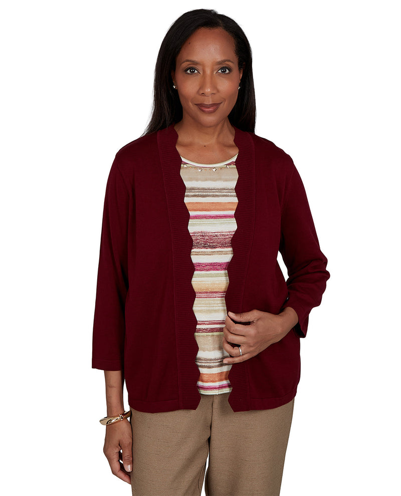 Woman wearing a burgundy cardigan over a striped shirt on a white background