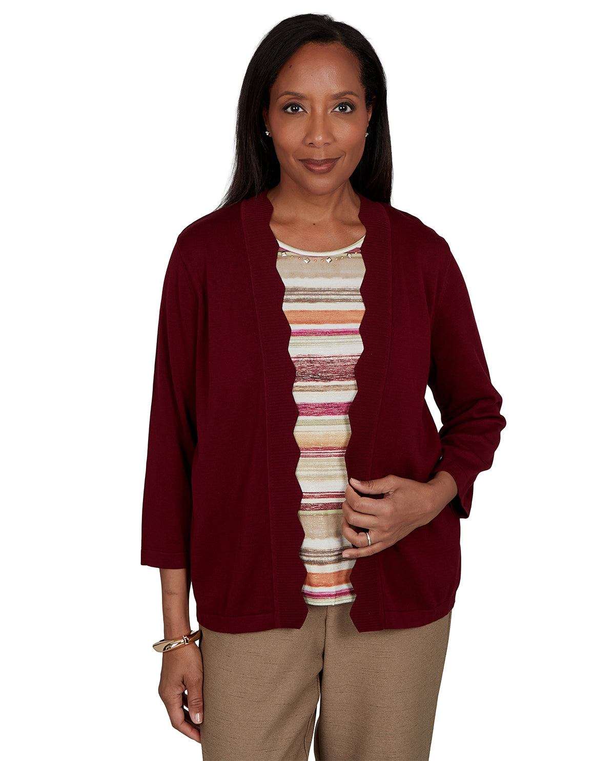Woman wearing a burgundy cardigan over a striped shirt on a white background