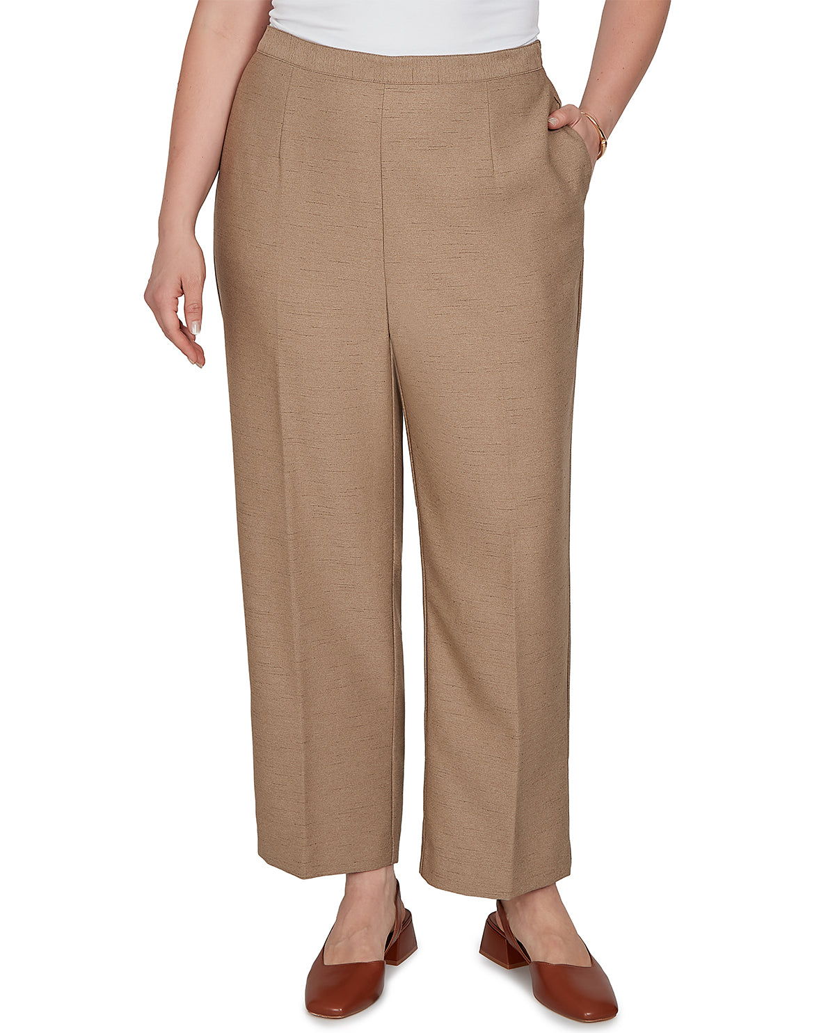 A model wearing a pair of cropped, wide-leg trousers in a warm tan or camel color, paired with a white top and brown leather flats, shown against a plain white background.