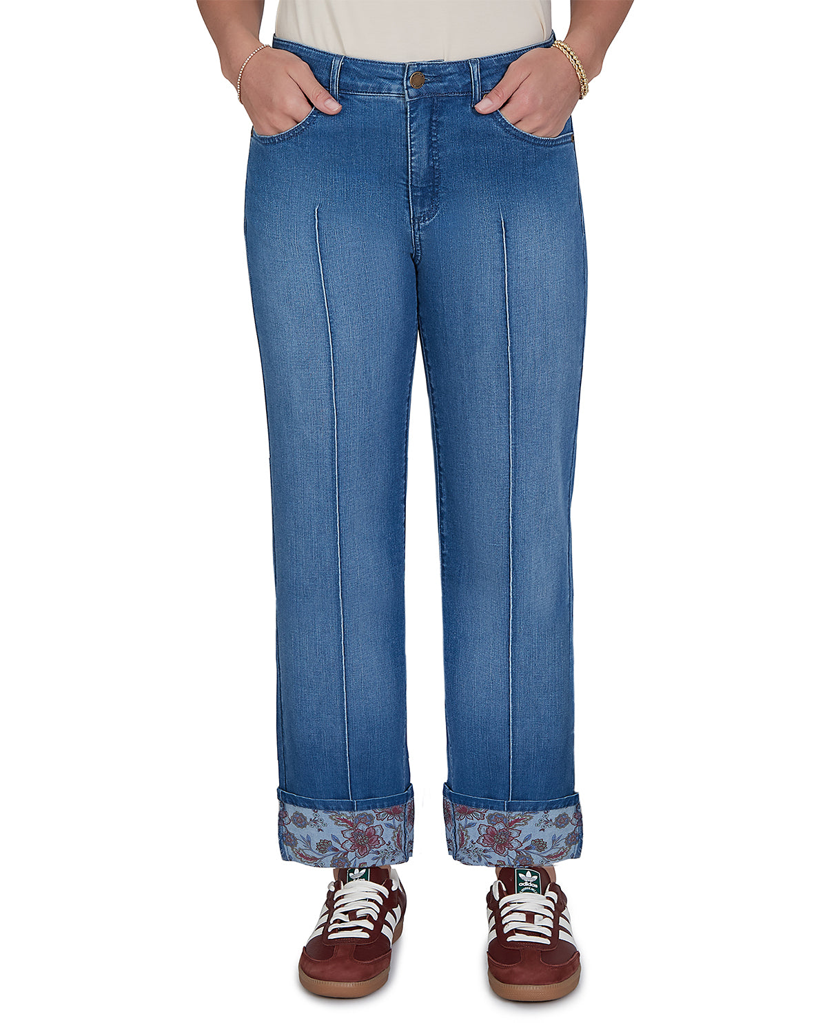 Person wearing blue jeans with rolled-up cuffs on a white background