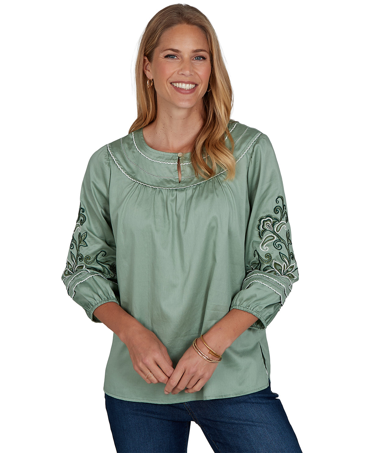 Woman wearing a green blouse with embroidery on a white background