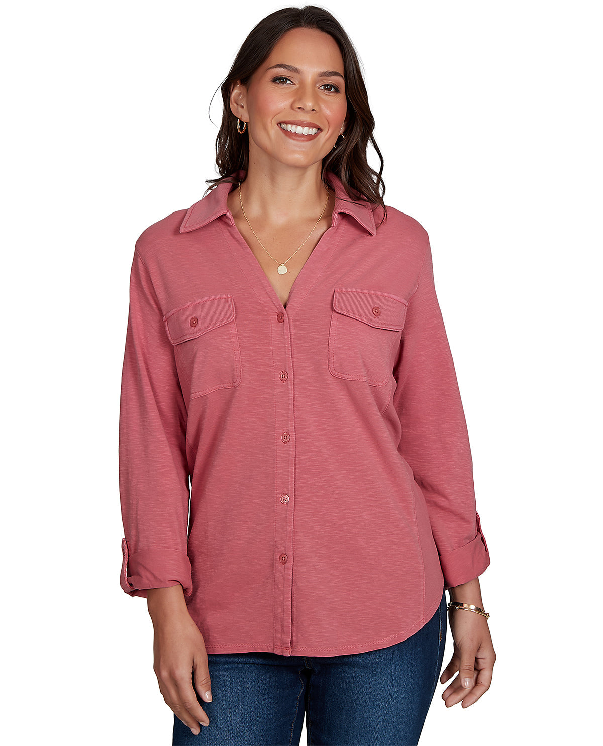 Woman wearing a pink button-up shirt with rolled-up sleeves on a white background