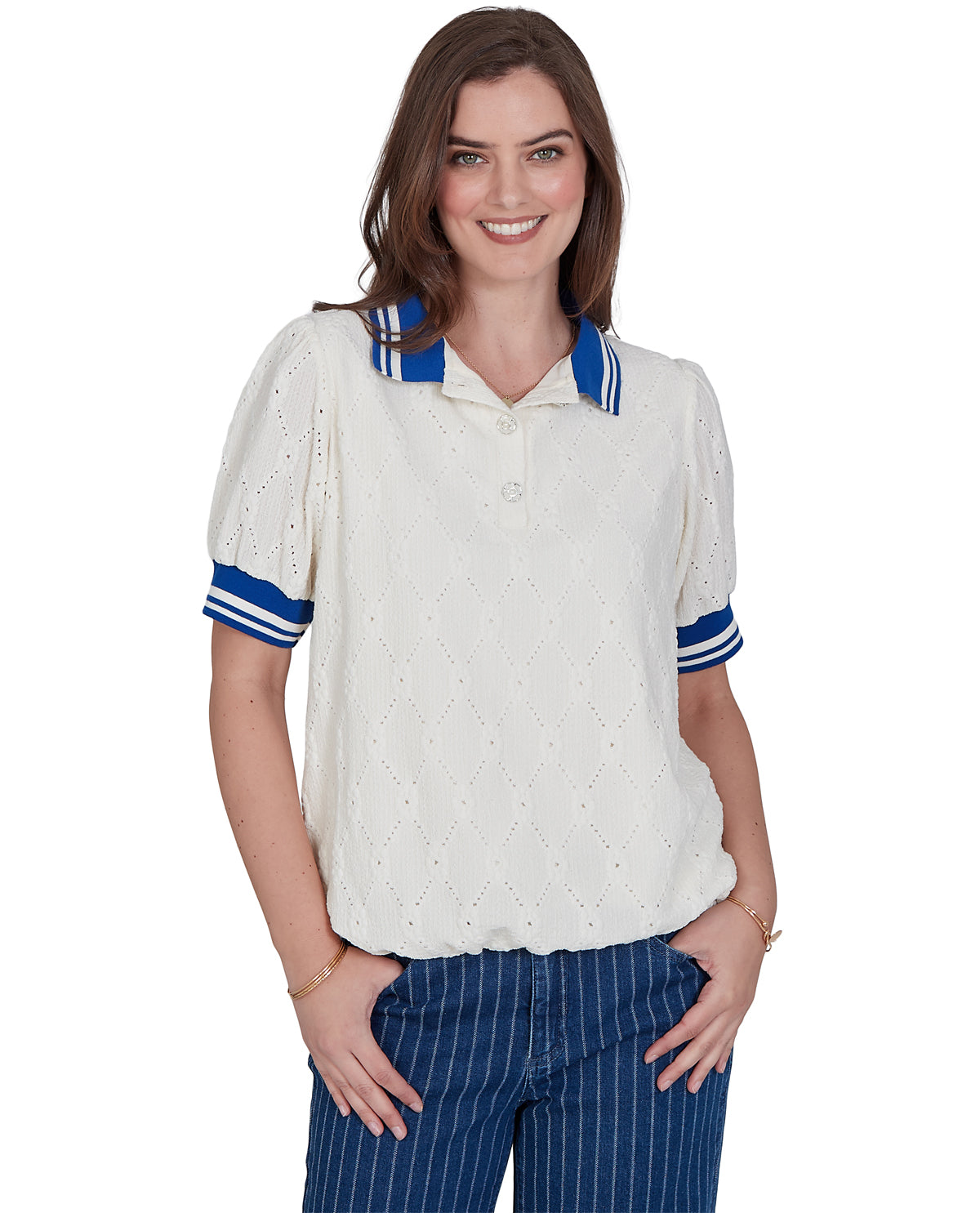 A woman modeling a short-sleeve knit polo shirt in off-white with blue and white striped accents on the collar and cuffs, paired with blue pinstriped pants against a plain white background.