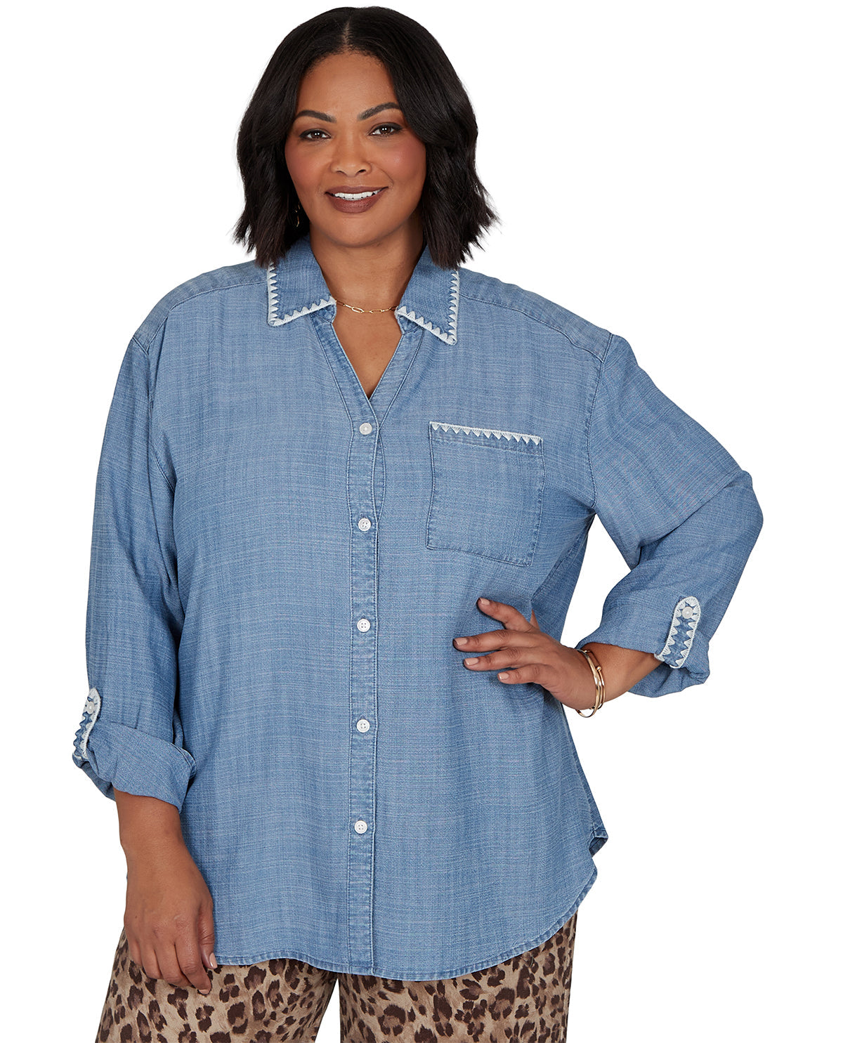 Woman wearing a blue denim shirt with rolled-up sleeves on a white background