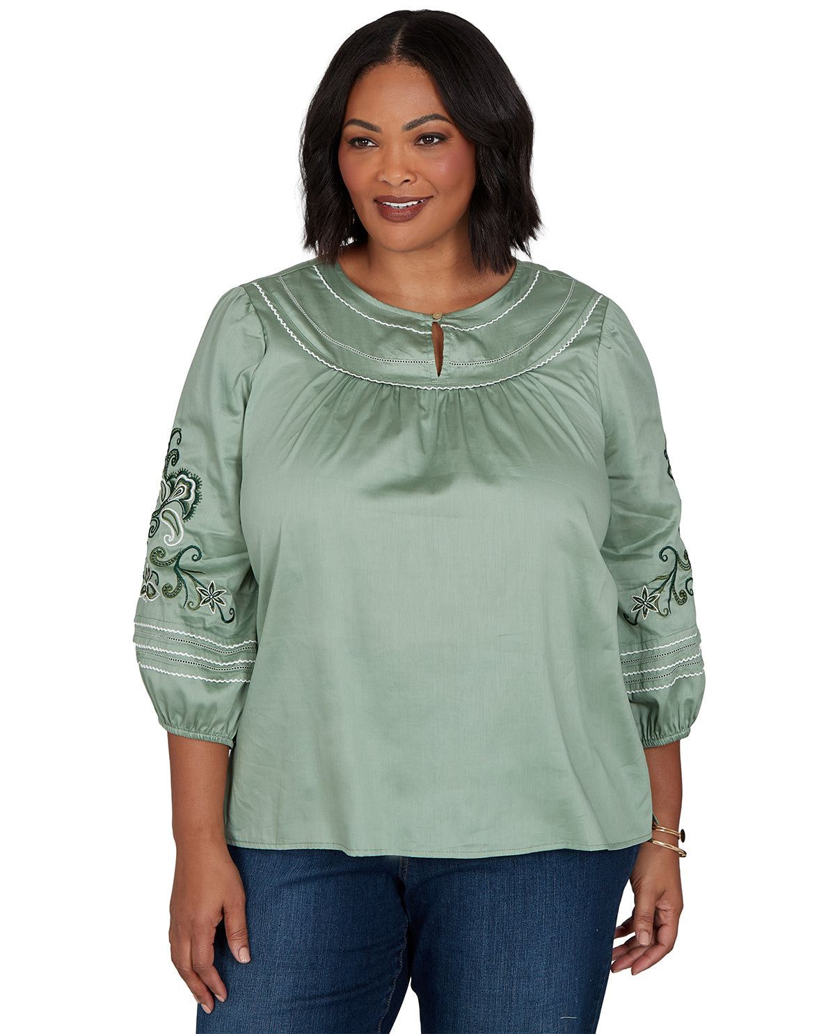 Woman wearing a green blouse with embroidery on a white background