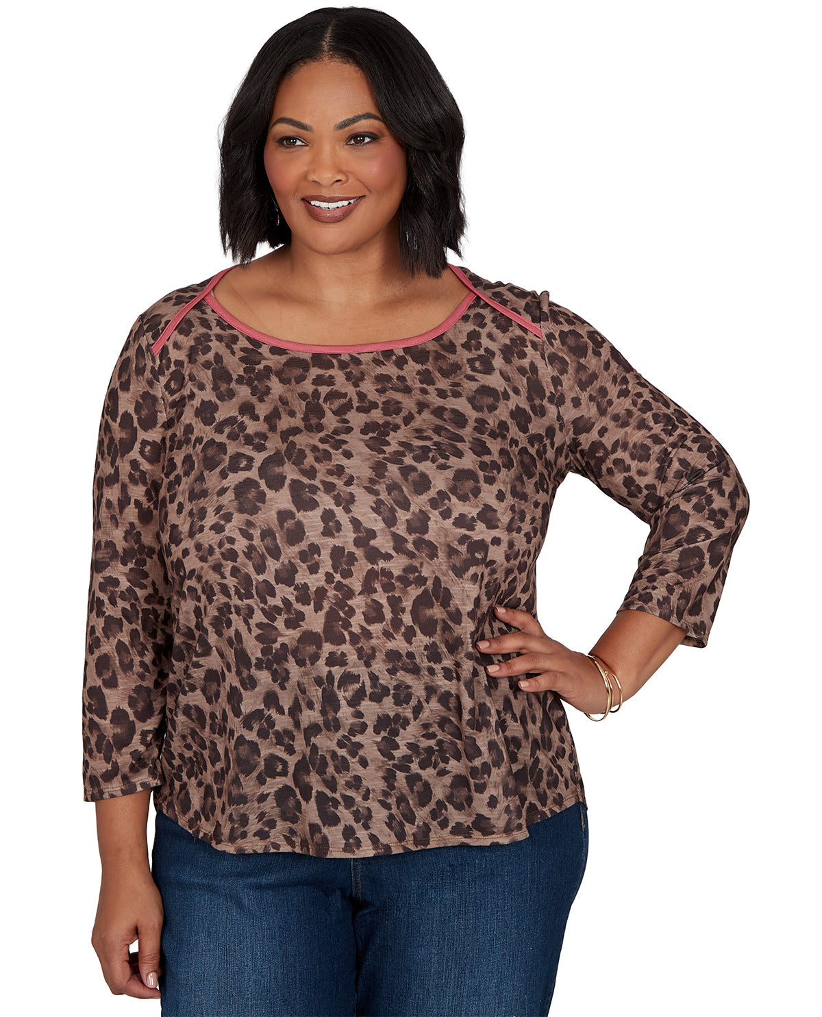 Woman wearing a leopard print top with pink trim on a white background