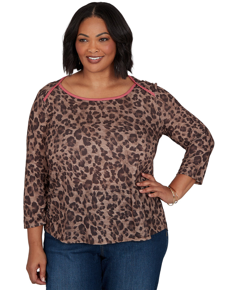Woman wearing a leopard print top with pink trim on a white background
