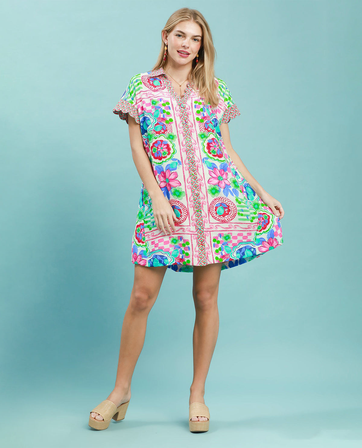Woman wearing a colorful patterned dress on a light blue background