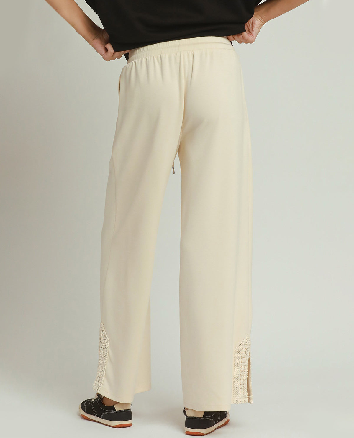 Person wearing beige wide-leg pants on a plain background