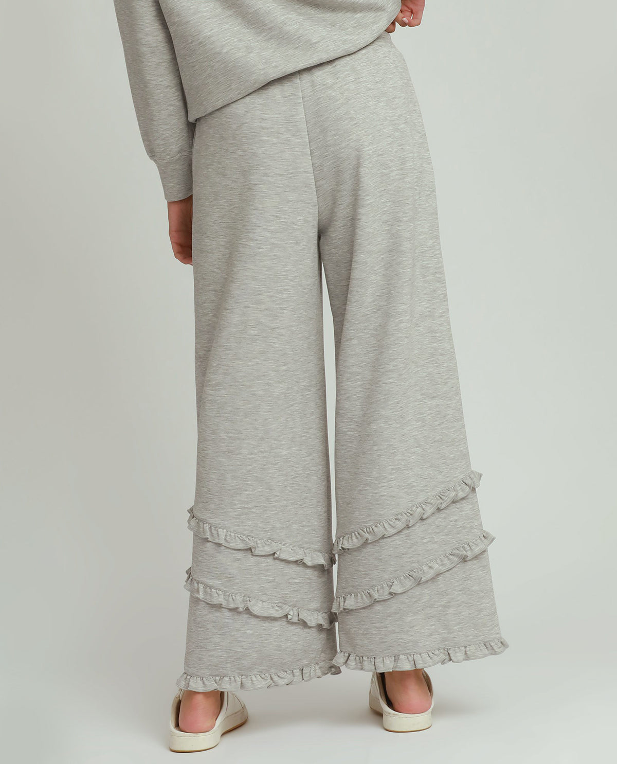 Gray wide-leg pants with ruffled hem on a plain background
