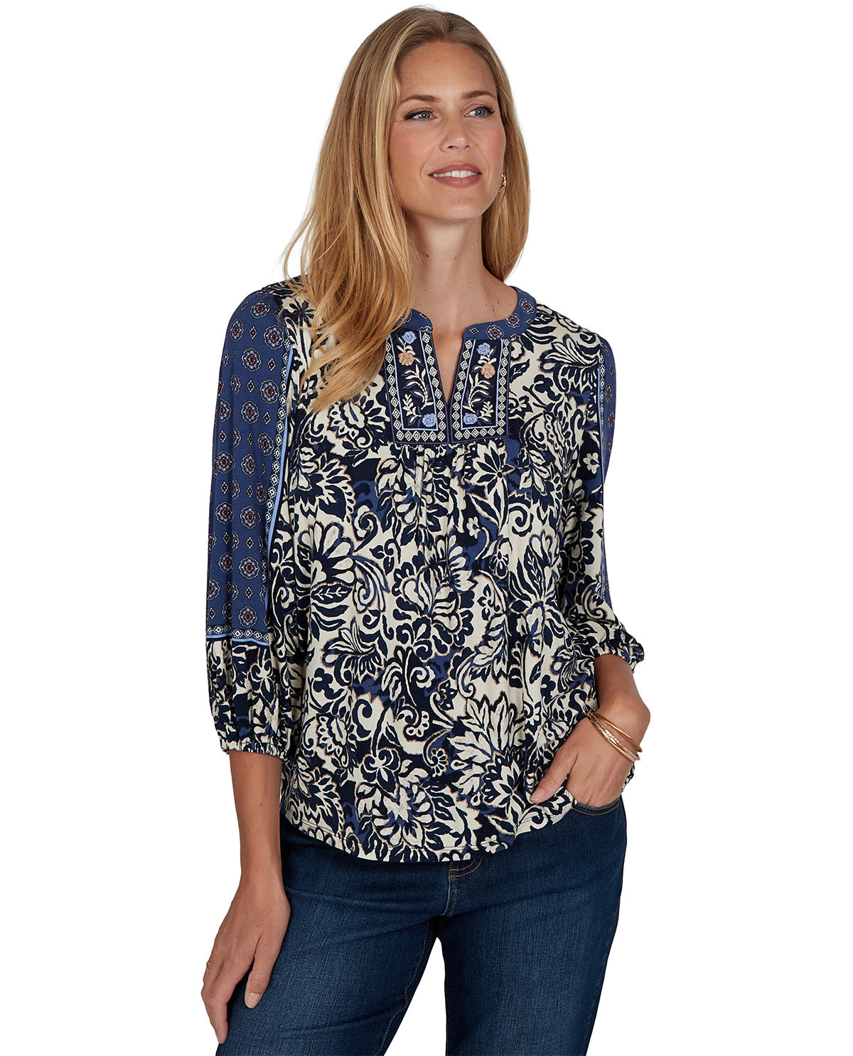 Woman wearing a patterned blouse with rolled-up sleeves on a white background