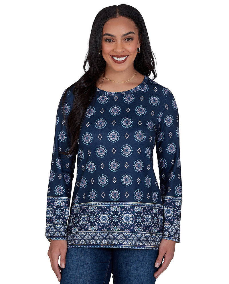 Woman wearing a navy blue patterned long-sleeve shirt on a white background