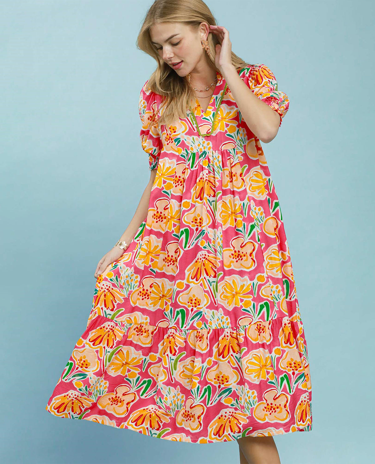 Woman wearing a colorful floral dress against a light blue background