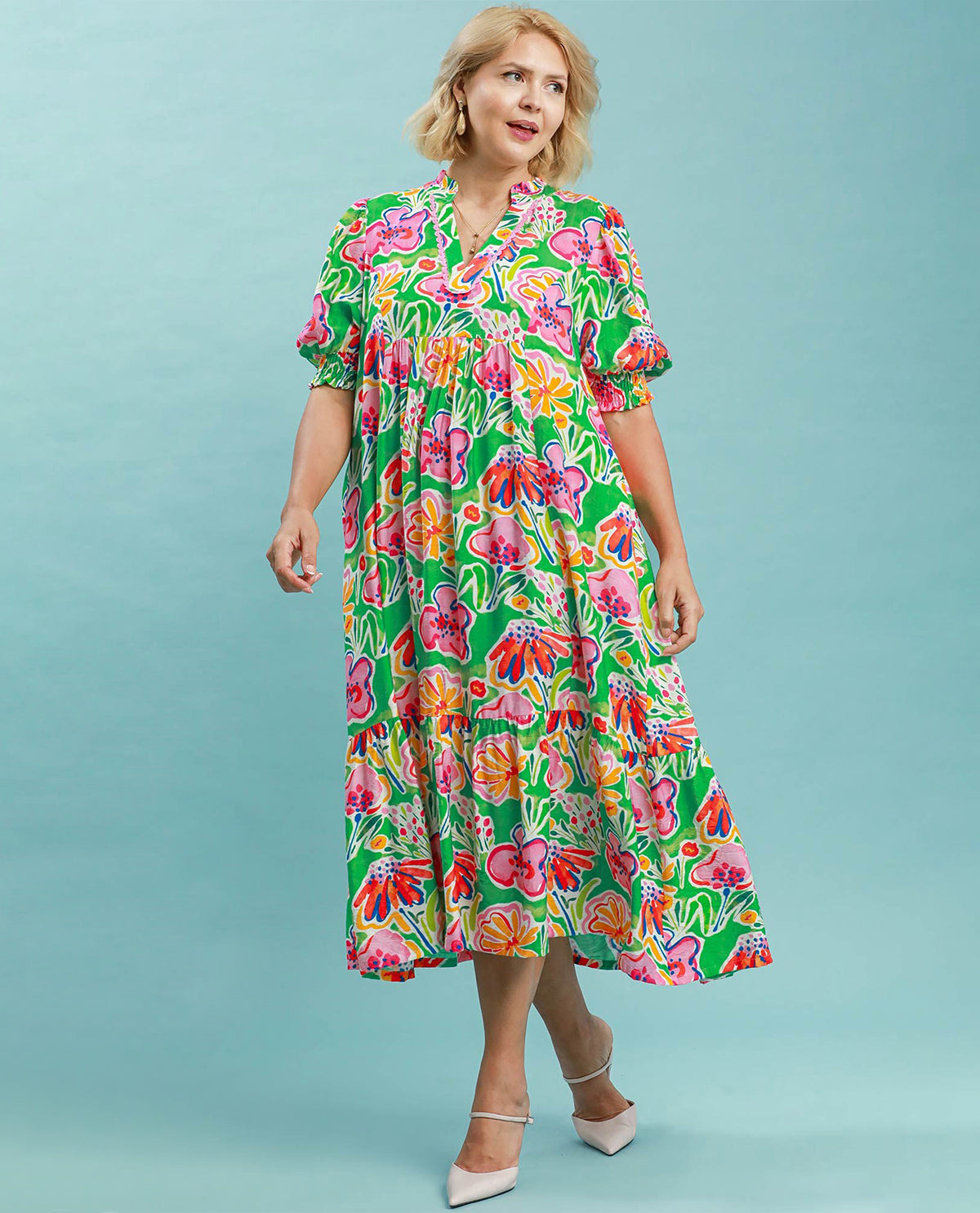 Woman wearing a colorful floral dress against a light blue background