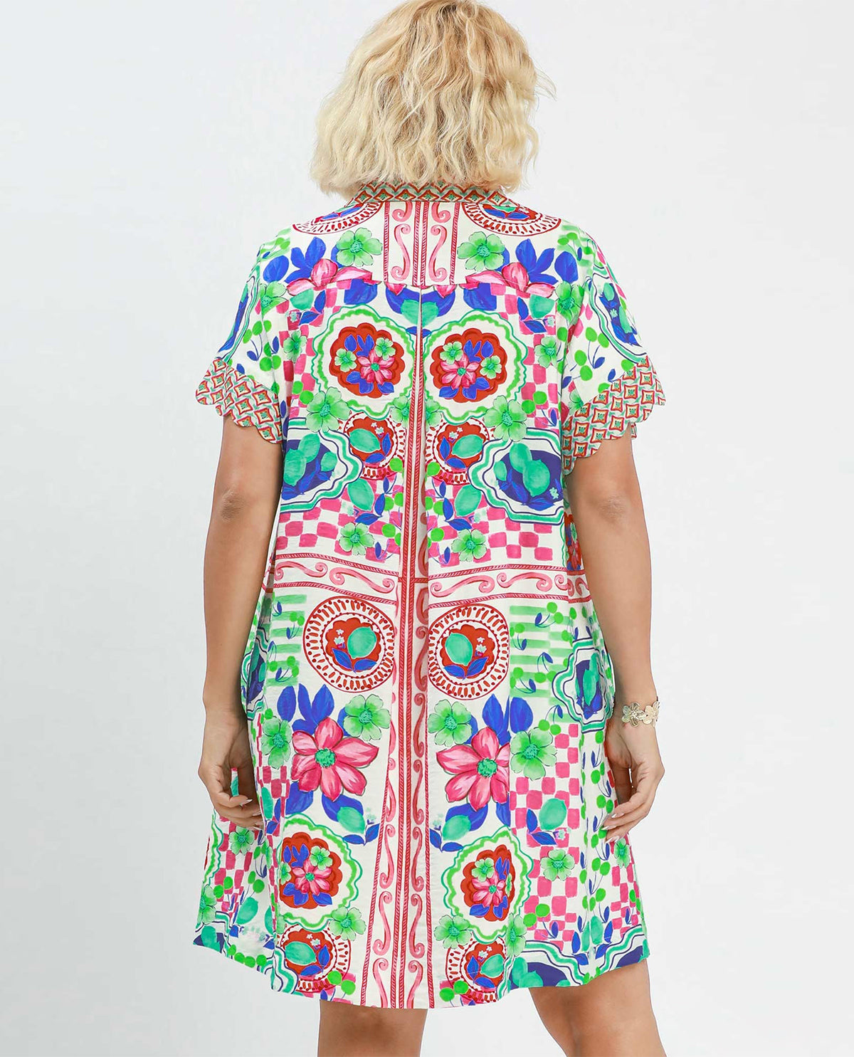 Woman wearing a colorful patterned dress on a white background