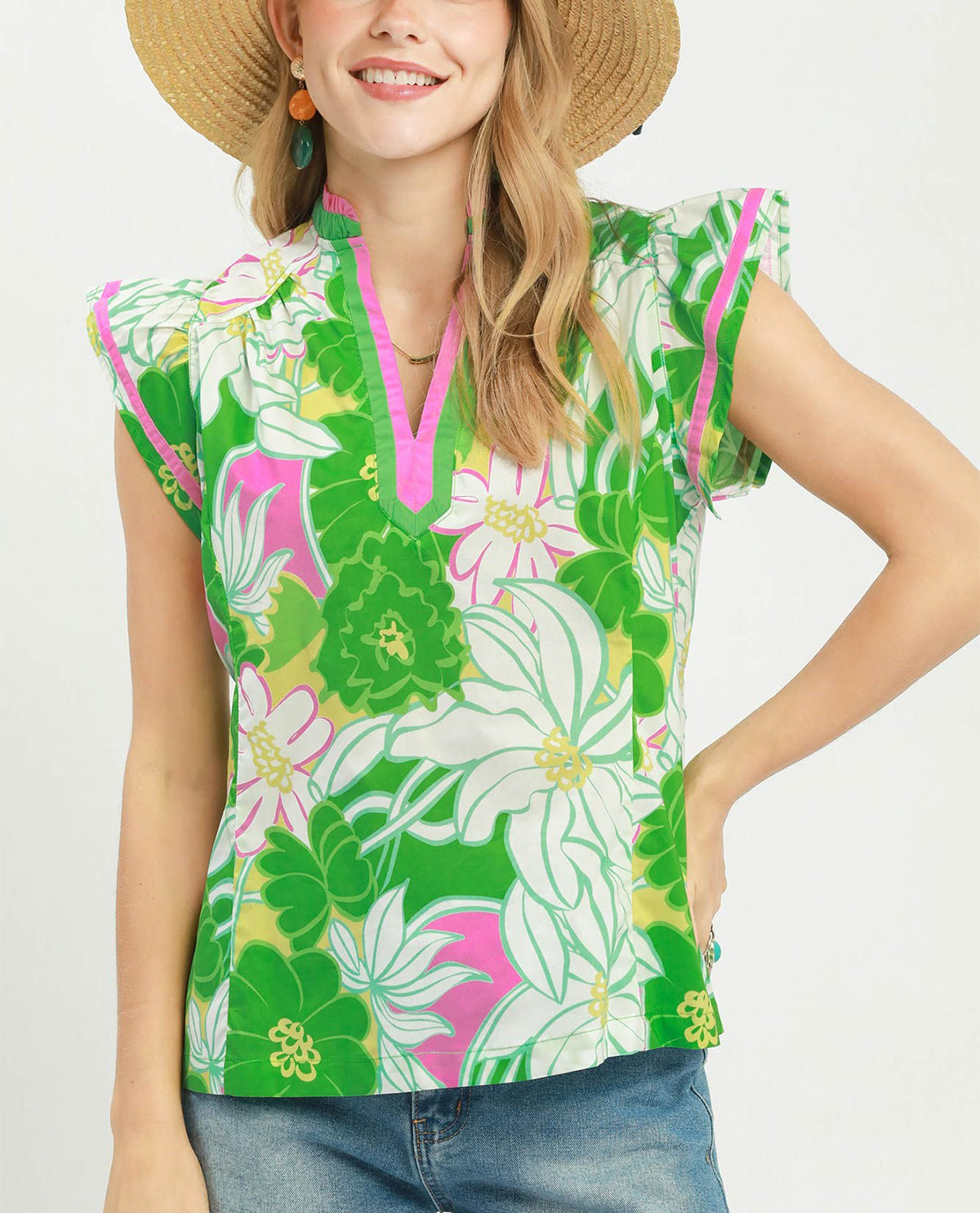 Woman wearing a colorful floral sleeveless top with a white background