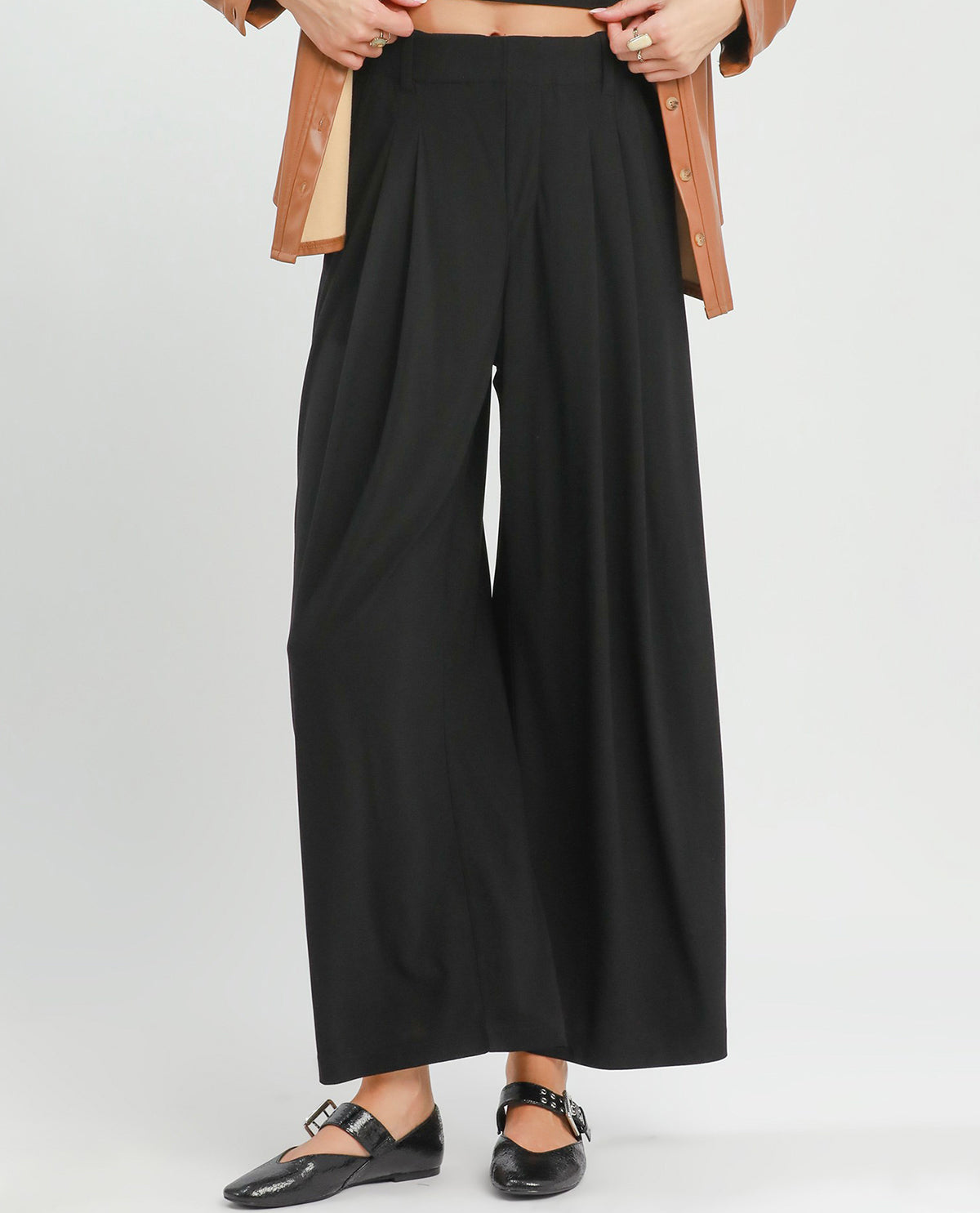 Black wide-leg pants worn by a person on a white background