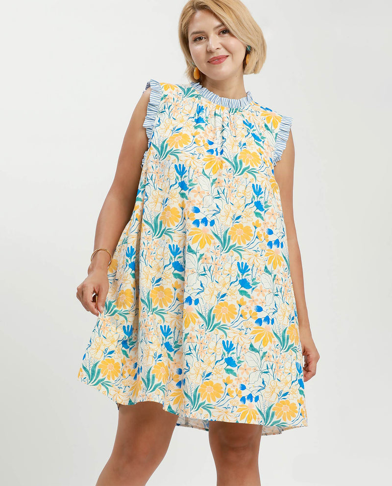 Woman wearing a floral dress with yellow and blue flowers on a white background