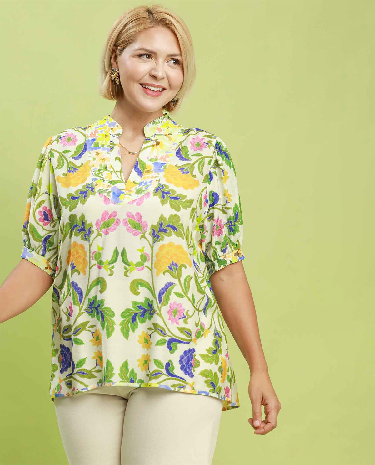 Woman wearing a floral blouse against a green background