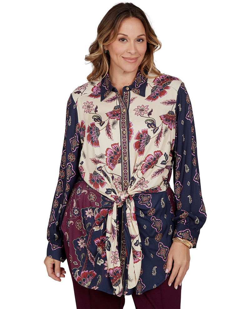 Woman wearing a long floral patterned shirt on a white background