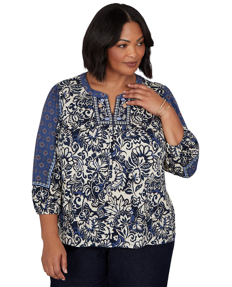 Woman wearing a blue and white patterned blouse on a white background