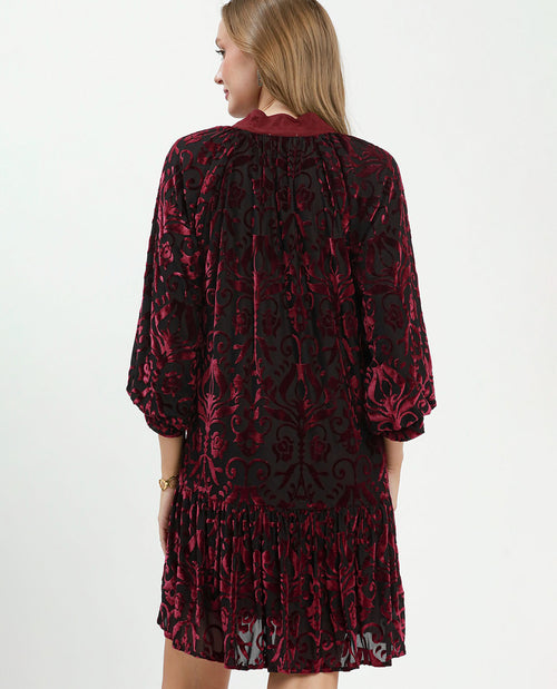 Woman wearing a black and red patterned dress on a white background