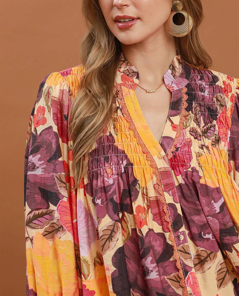 Woman wearing a colorful floral dress against a brown background