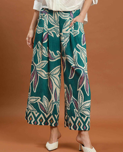 Person wearing teal patterned pants on a brown background