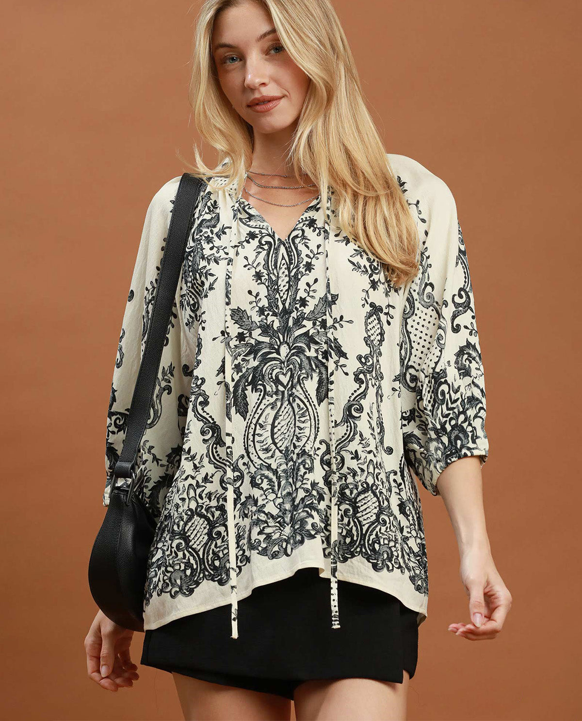 Woman wearing a patterned blouse with a brown background