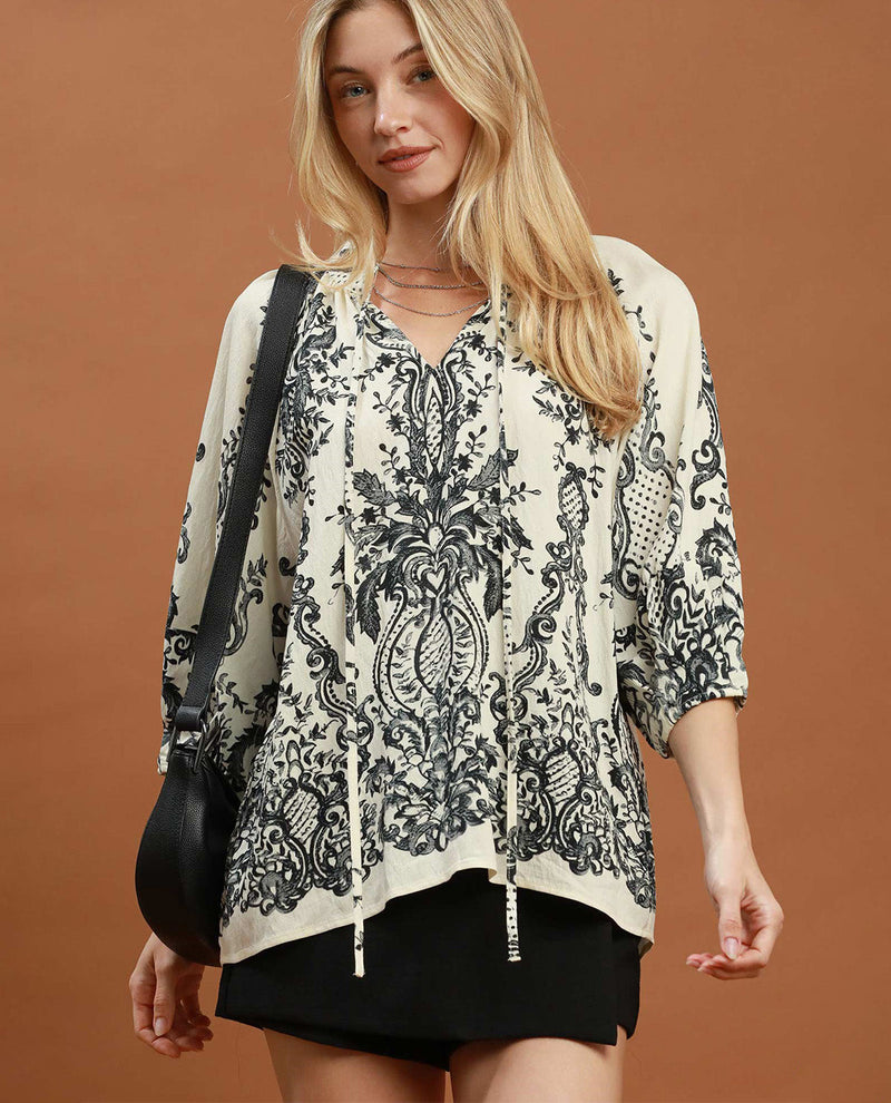 Woman wearing a patterned blouse with a brown background