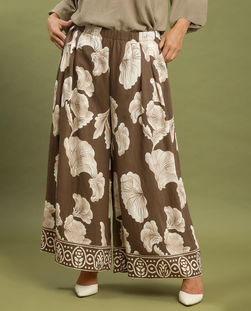 Floral patterned pants on a person against an olive green background