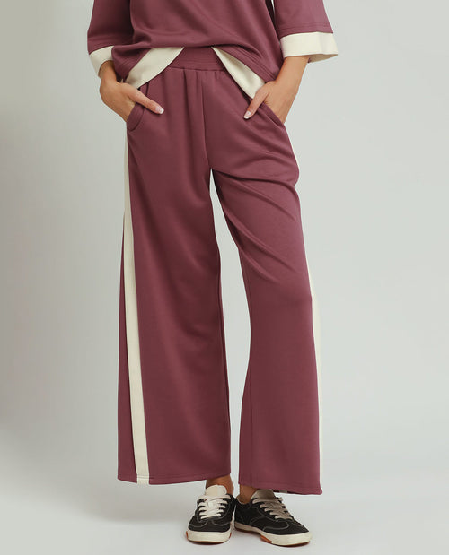 Maroon pants with white stripes on a plain background