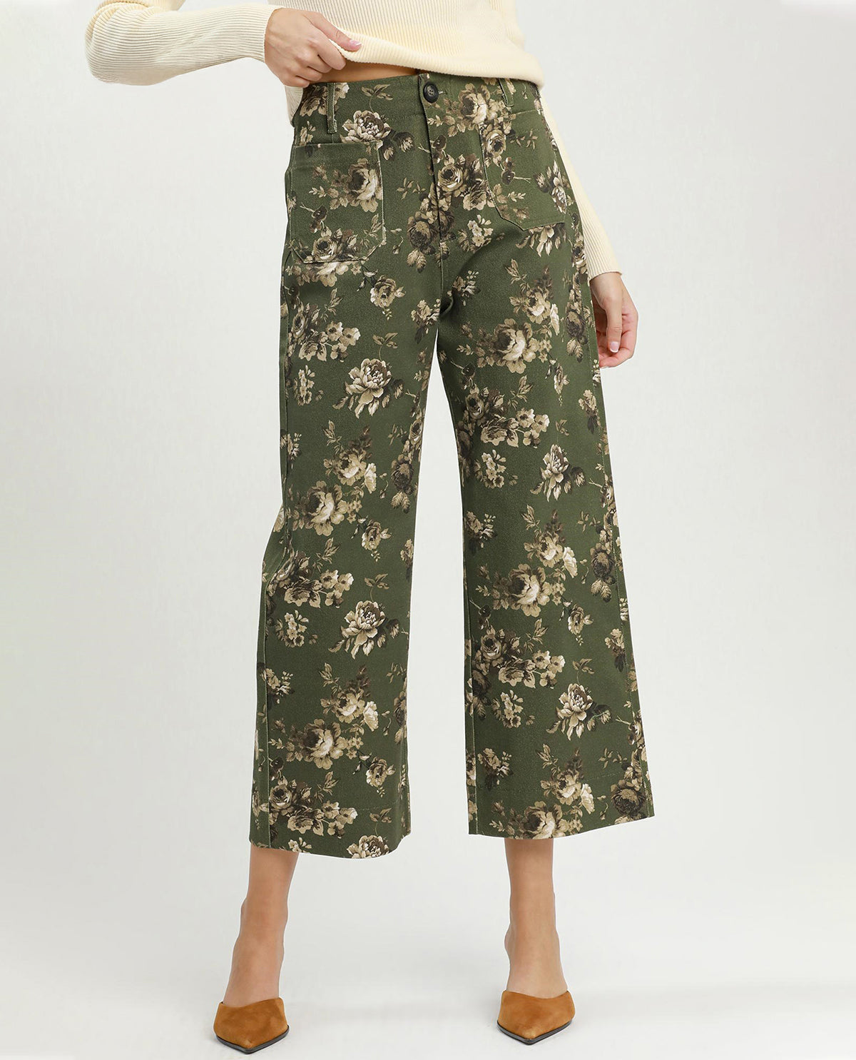 Green floral-patterned pants worn by a person on a white background