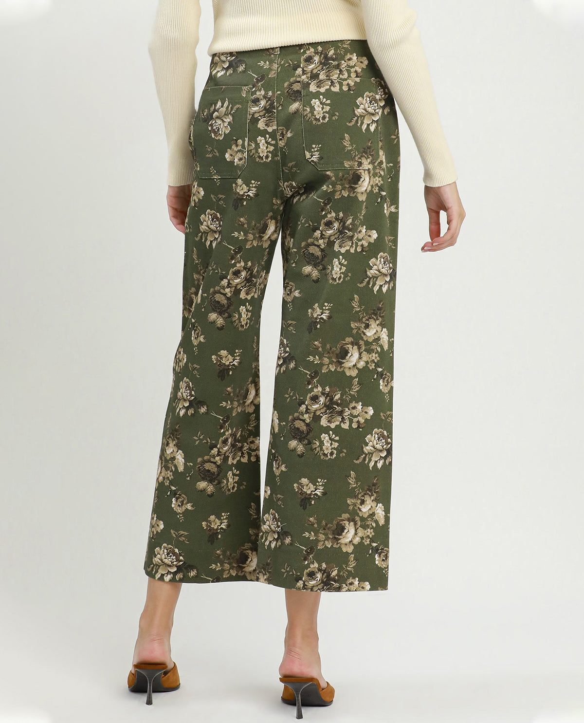 Person wearing green floral pants on a white background