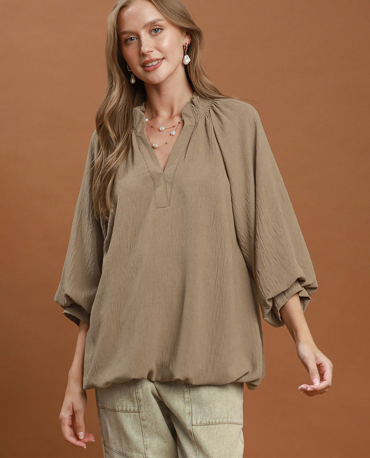 Woman wearing a brown blouse against a brown background