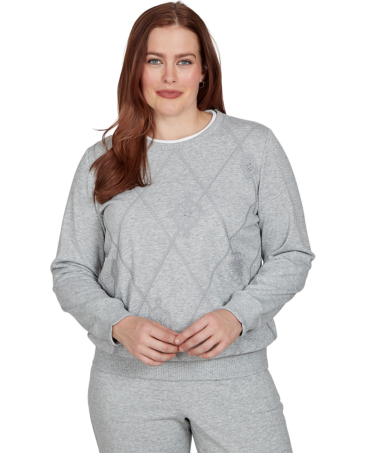 A woman modeling a light gray heather crewneck sweatshirt and matching sweatpants against a plain white background.