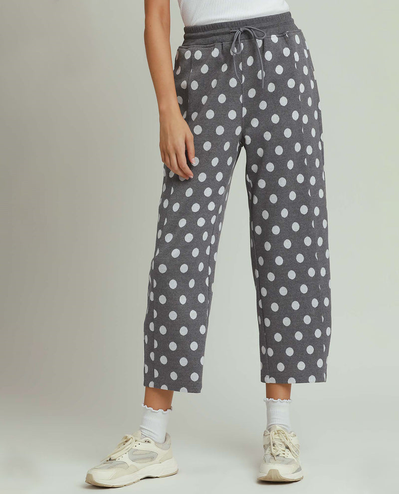 Person wearing gray polka dot pants on a plain background