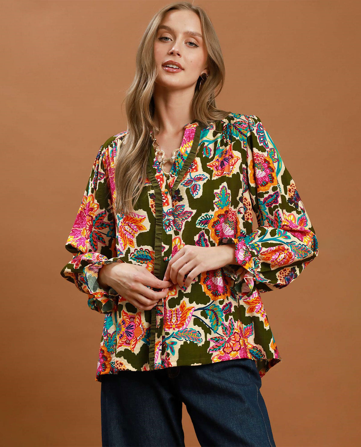 Woman wearing a colorful floral blouse against a brown background