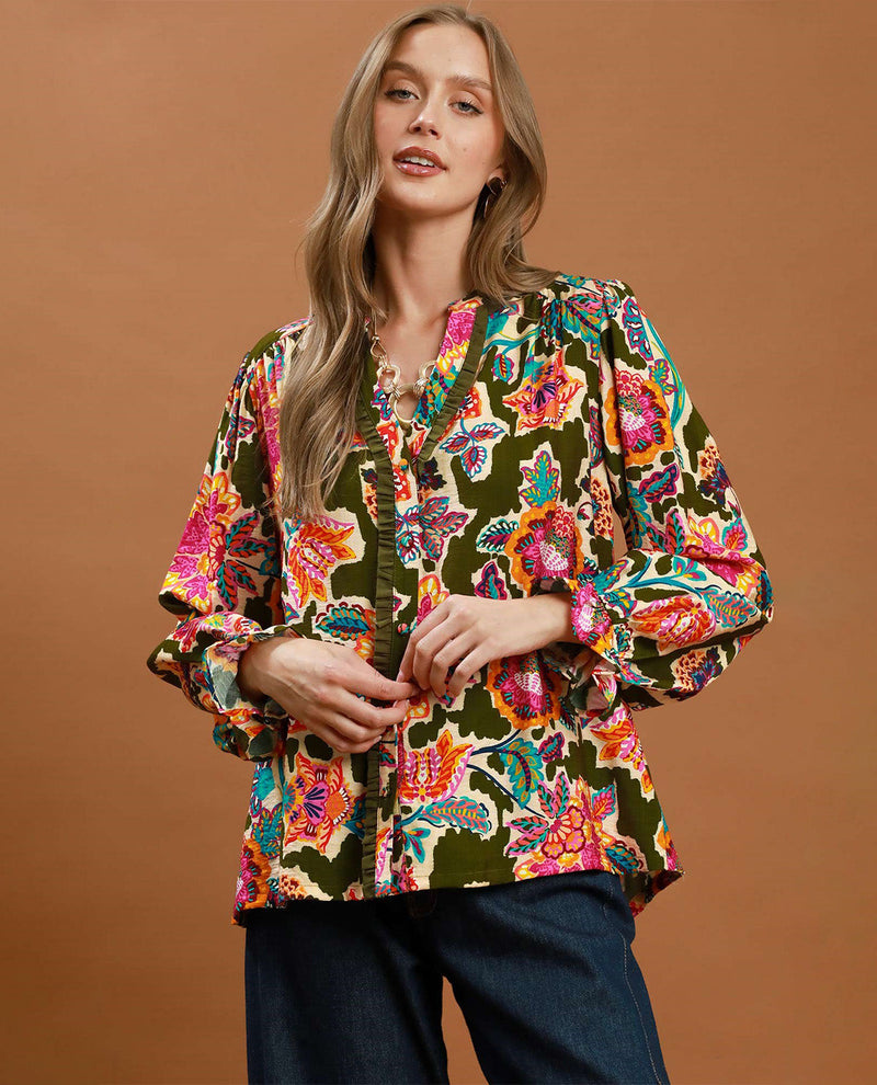 Woman wearing a colorful floral blouse against a brown background