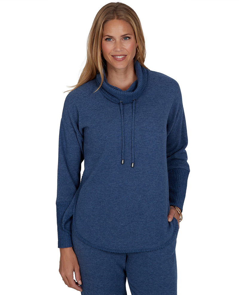 Woman wearing a blue cowl-neck sweater on a white background