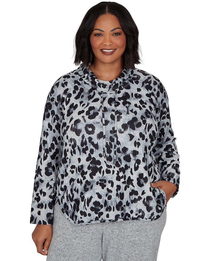 Woman wearing a leopard print top and gray pants on a white background