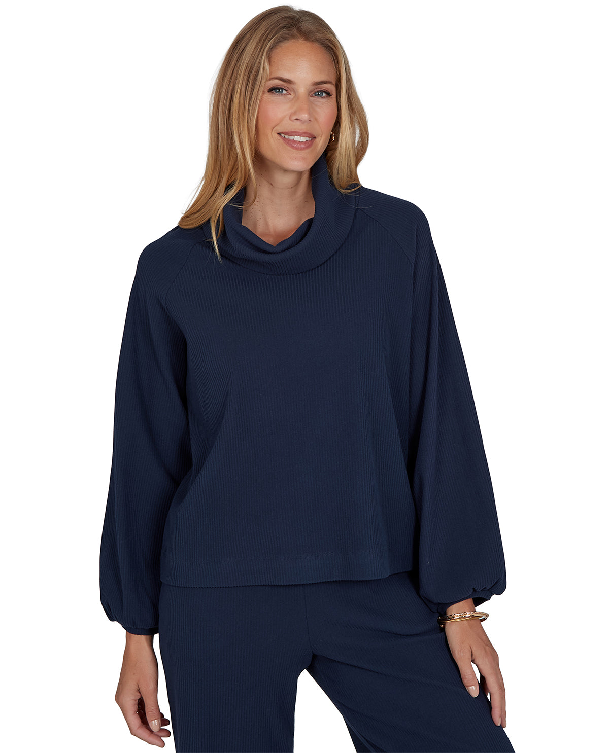 Woman wearing a navy blue cowl-neck sweater on a white background