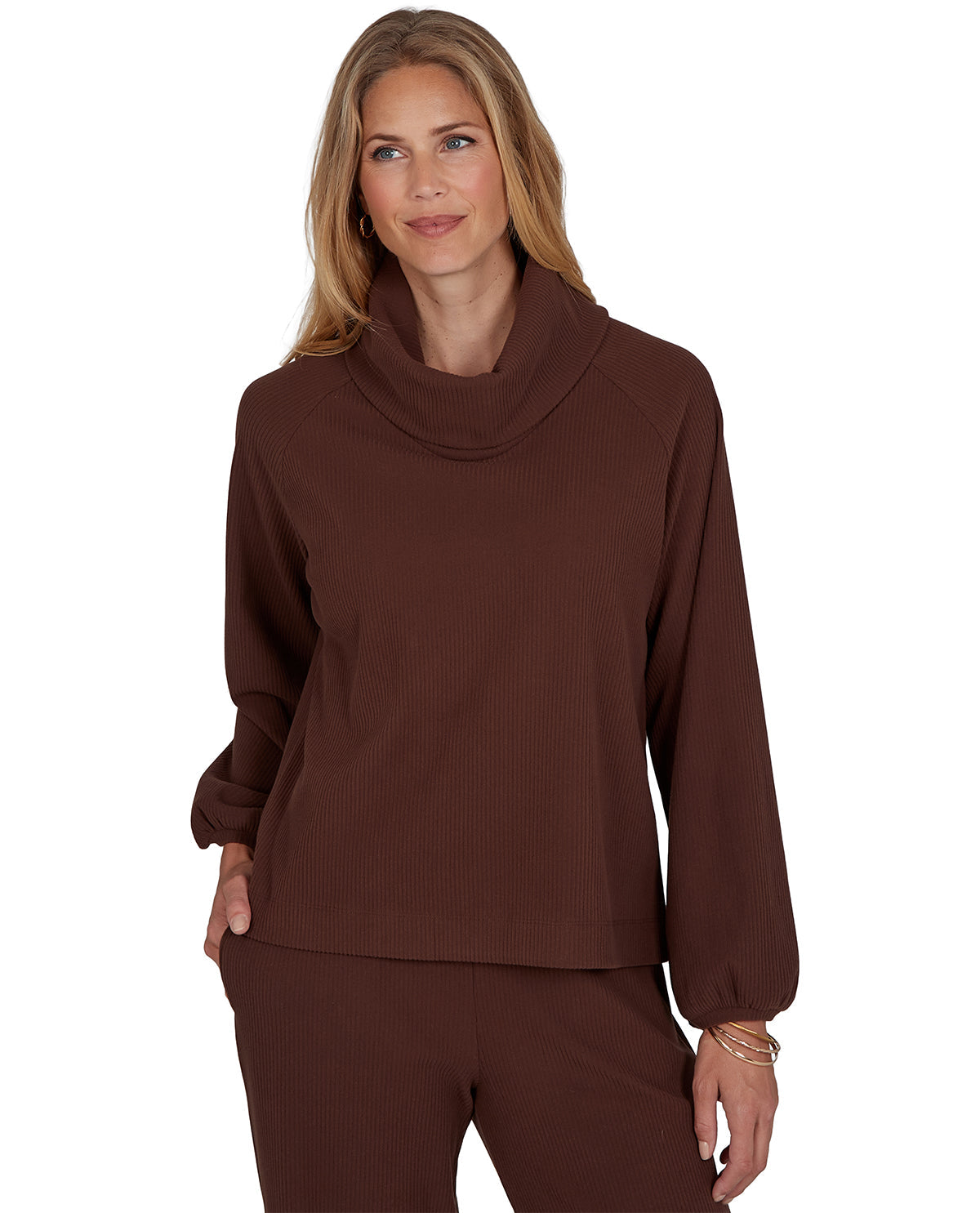 Woman wearing a petite brown cowl-neck top and pants on a white background