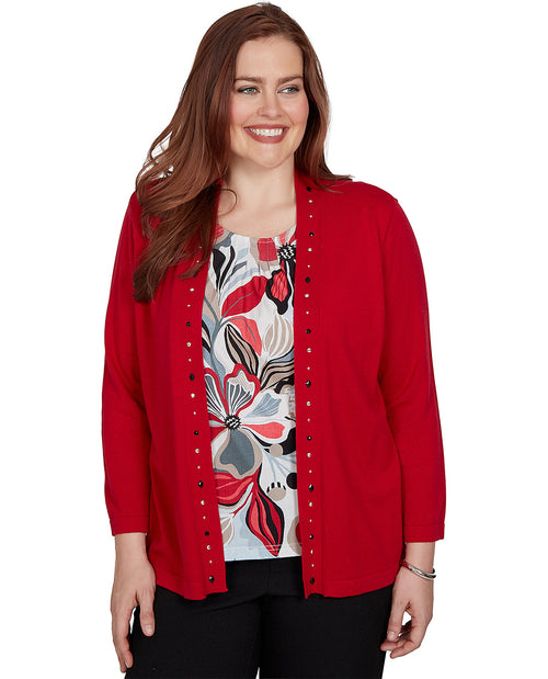 A woman modeling a bright red open-front cardigan with decorative black buttons over a white floral print top and black pants, set against a plain white background.