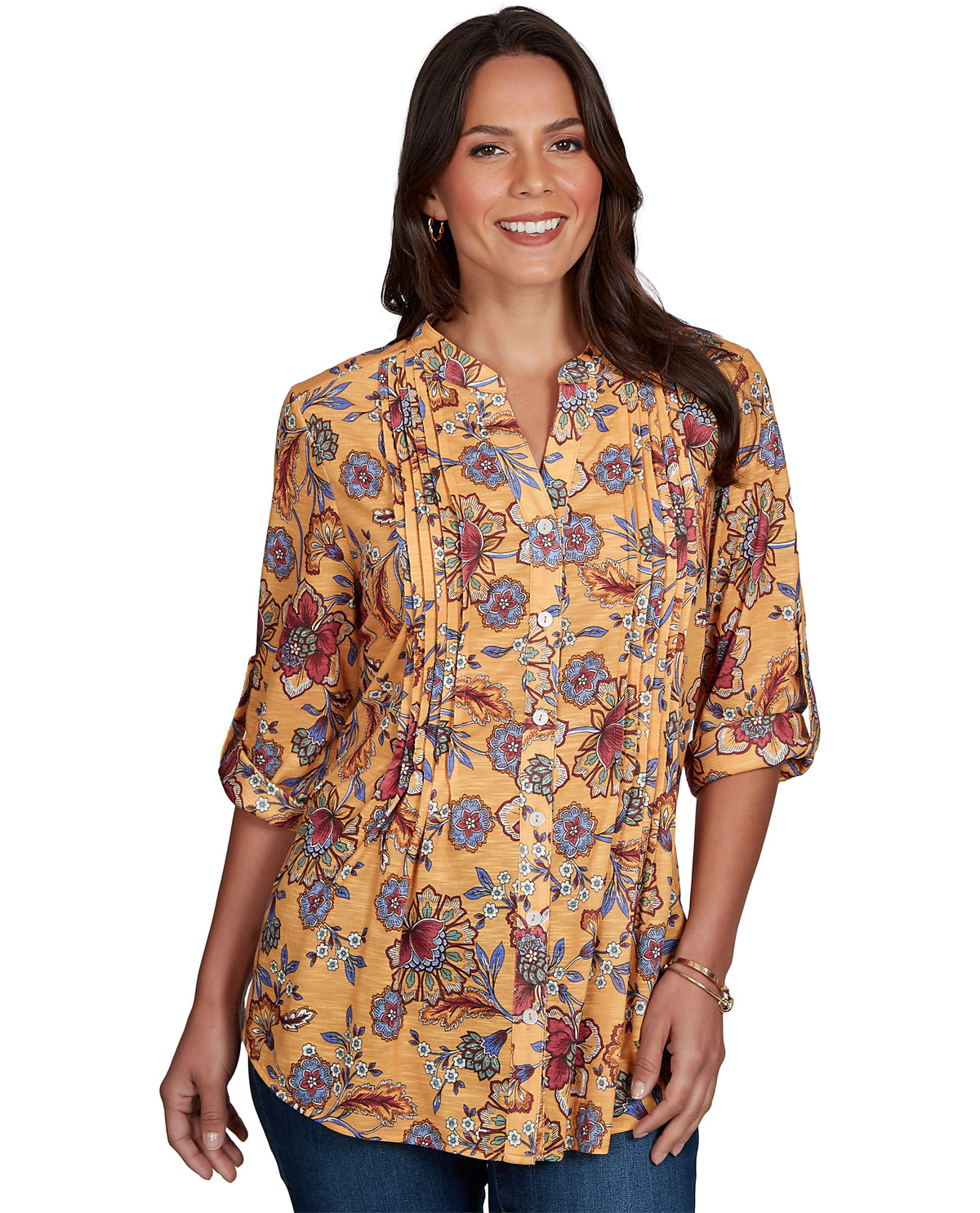 A woman modeling a yellow-orange floral print blouse with three-quarter sleeves and a split neckline, paired with blue jeans against a plain white background.